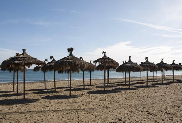Zandstrand met ligbedden