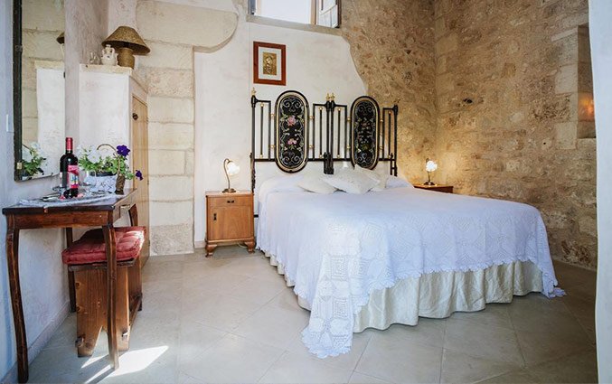 Tweepersoonsbed in kamer met muur Hotel Borgoterra in Puglia