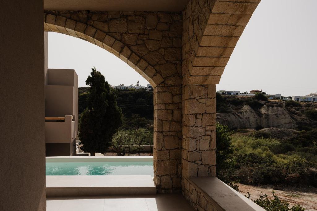 Momi Slow Living Hotel - stenen boog met zwembadzicht