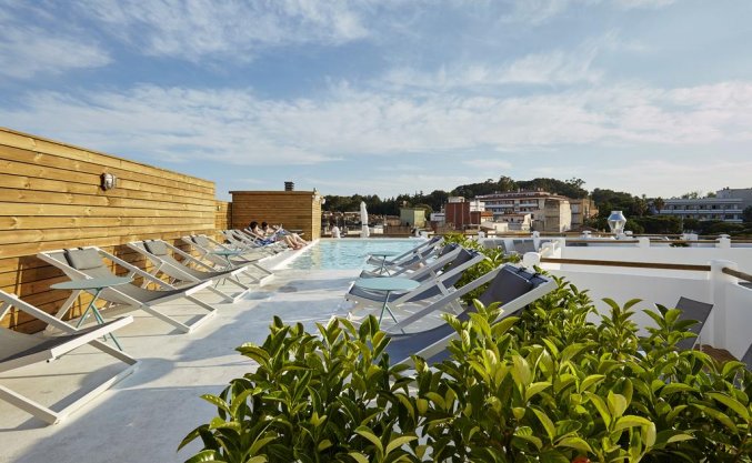 Ligbedden en zwembad van Hotel Delamar in Lloret de Mar